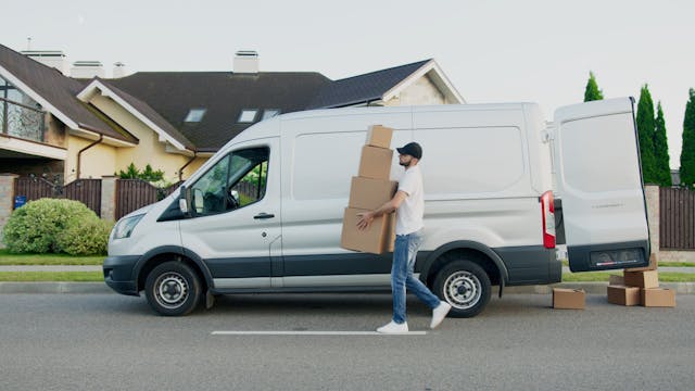 man-carrying-boxes-beside-a-van